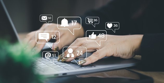Social Media Icons unterlegt mit Bild von Person an Laptop
